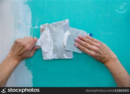 Plastering man hands with plaste on drywall plasterboard hydrophobic construction
