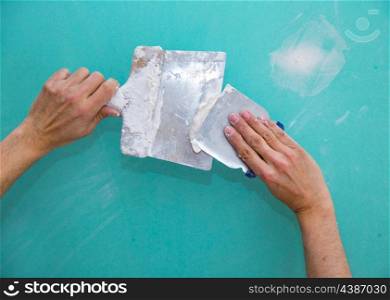 Plastering man hands with plaste on drywall plasterboard hydrophobic construction