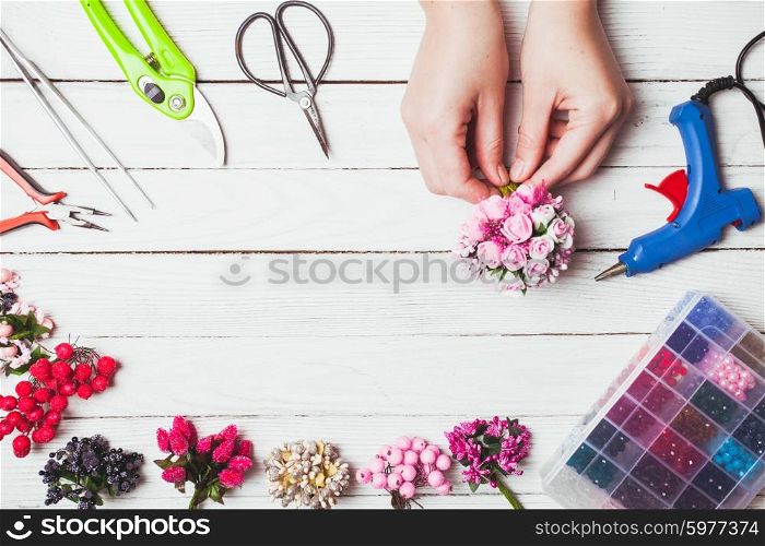 Plastic berries, flowers, beads and instruments for doing handmade decorations and bijouterie. Top view