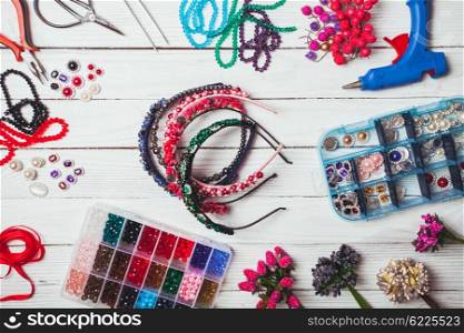 Plastic berries, flowers, beads and instruments for doing handmade headbands. Top view