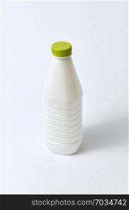 Plastic blank white bottle for milk and other liquid with green cap on a light gray background, copy space.. Mock-up dairy bottle from plastic on a light background.