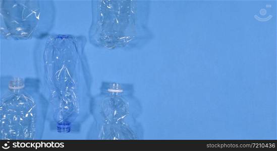 Plastic bottles isolated on blue background. Seamless pattern. Recycle waste management concept. Plastic Pet Bottles. Copy space