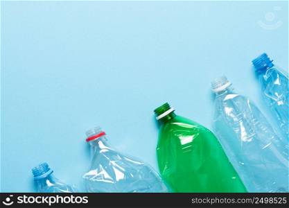Plastic bottles on blue background top view