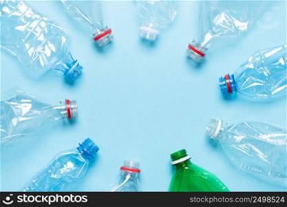 Plastic bottles on blue background top view. Recycle plastic waste pollution concept.