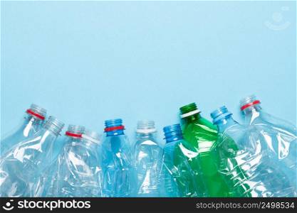 Plastic bottles recycle border on blue background with copy-space.