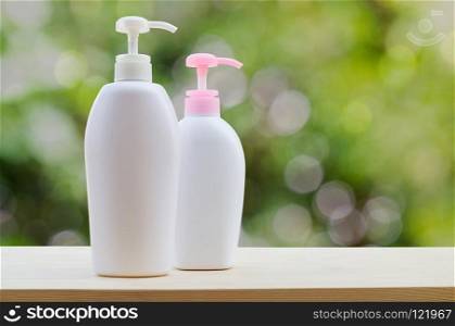 Plastic bottles with liquid soap or shower gel isolated on green background