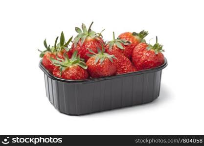 Plastic box with fresh strawberries on white background
