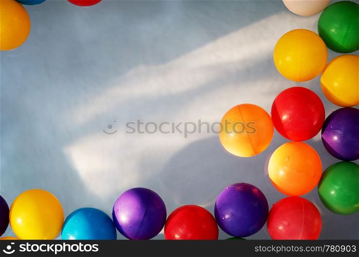 Plastic colored balls in the children?s pool on the background of blue water. Plastic colored balls in the children?s pool