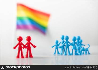 Plastic figures of gay couple, LGBT rainbow flag and heterosexuals on light gray background. Equal rights for lgbtq community concept