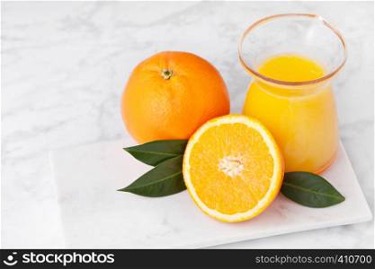 Plastic jar of fresh orange juice with fruits on marble background