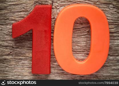 Plastic number ten on the wooden background
