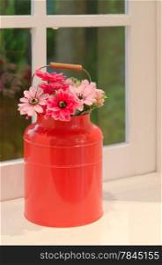 plastic pink and red flowers in red vase on table. flowers