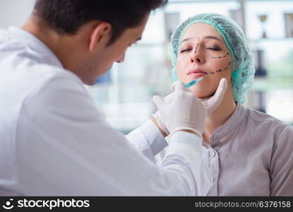 Plastic surgeon preparing for operation on woman face