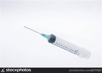 Plastic syringe on a soft gradient background, studio shot, high depth of feild
