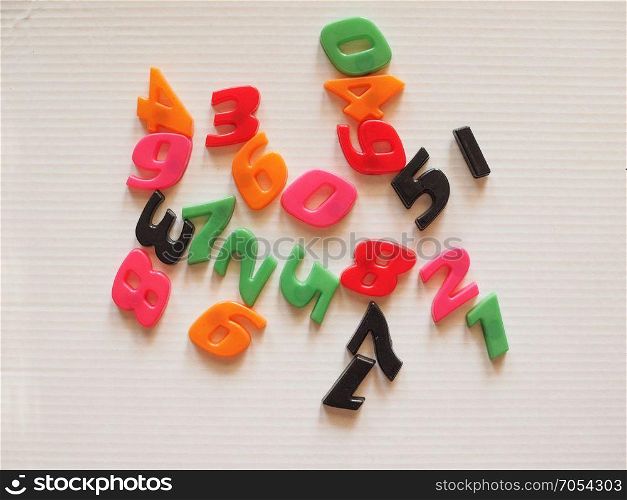 Plastic toy numbers. Plastic toy magnetic numbers from zero to nine in random order over white corrugated cardboard