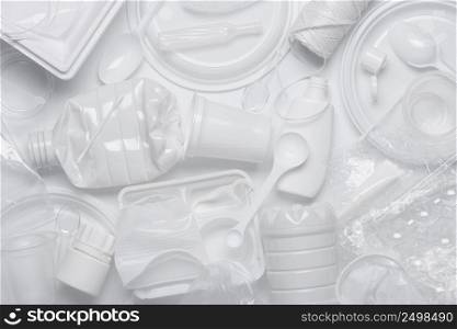 Plastic waste. Single-use plastic objects, ecological pollution. White packaging plastic products, top view flat lay.