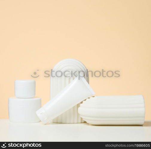 plastic white container for cosmetics on a white table. Jar and tuba, product demonstration and promotion