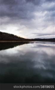 Plastiras lake view with sky reflected in water, in central Greece