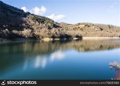 Plastiras lake view with sky reflected in water, in central Greece