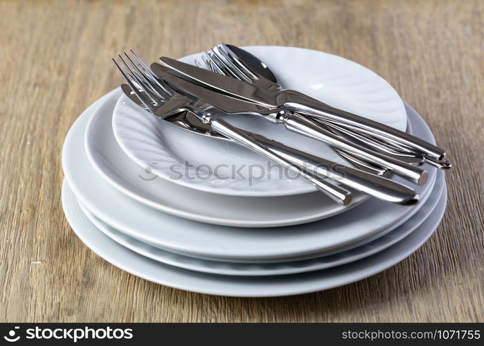 plate and cutlery on a wooden background. plate and cutlery