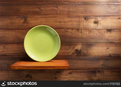 plate at kitchen wooden shelf at wall background