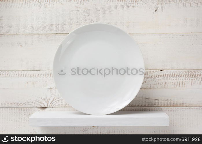 plate at shelf on white wooden plank background