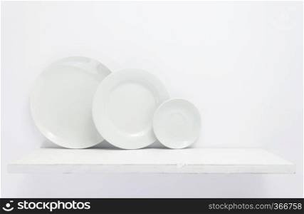 plate at wooden shelf on white background