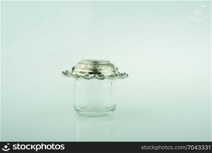 Plate covers the top of a little empty jar on a colorful background