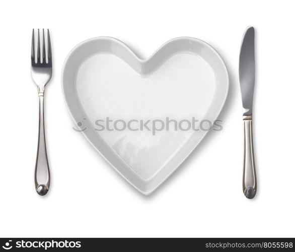 plate in shape of heart, table knife and fork isolated on white