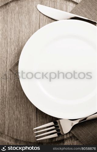 plate, knife and fork at cutting wooden board