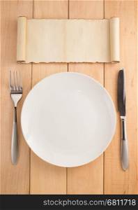 plate, knife and fork on wooden background