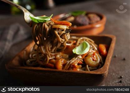 Plate of asian buckwheat soba noodles with vegetables, mushrooms and chicken.
