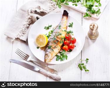 plate of baked sea bass on wooden table