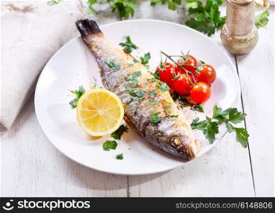 plate of baked sea bass on wooden table