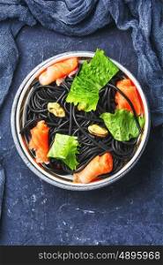 plate of black spaghetti with black mussels and and trout