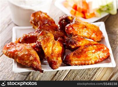 plate of chicken wings on wooden table