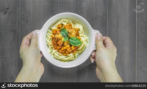 Plate of delicious spaghetti bolognese . Plate of delicious spaghetti bolognese with savory minced beef and tomato sauce garnished with basil, overhead view