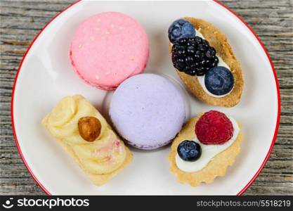 Plate of fancy desserts. Dessert plate with french macarons and pastries