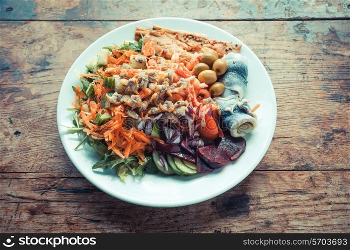 Plate of fish and salad on a wooden table