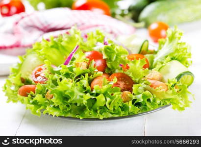 plate of fresh salad with vegetables on wooden table