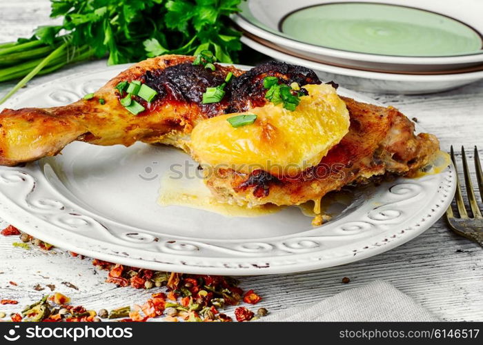 Plate of fried chicken thigh and fresh herbs.Light background. Fried chicken thighs