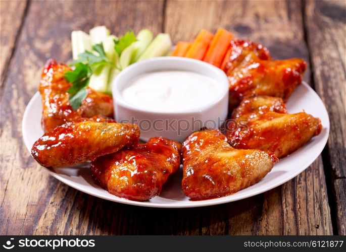plate of fried chicken wings with sauce