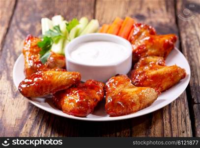 plate of fried chicken wings with sauce