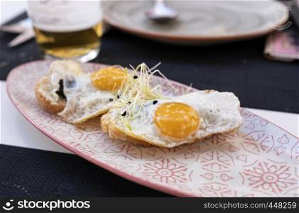 plate of fried eggs on crispy toast with truffle