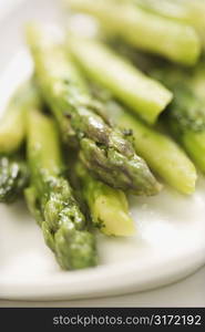 Plate of green cooked asparagus.