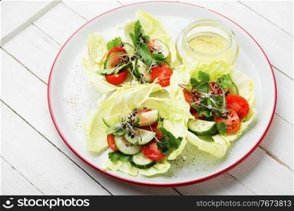Plate of green salad with summer vegetables.Salad with cabbage,cucumber,tomato and herbs.Healthy vegetable salad. Spring vegetable salad on plate
