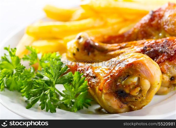 plate of grilled chicken legs with fries
