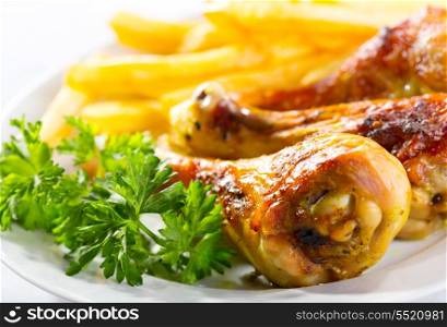 plate of grilled chicken legs with fries
