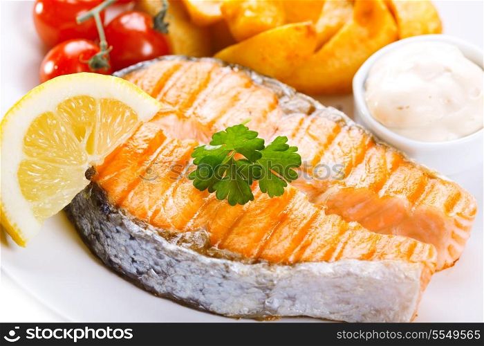 plate of grilled salmon steak with vegetables