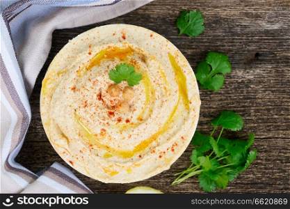 Plate of hummus on wooden table, top view. Plate of hummus